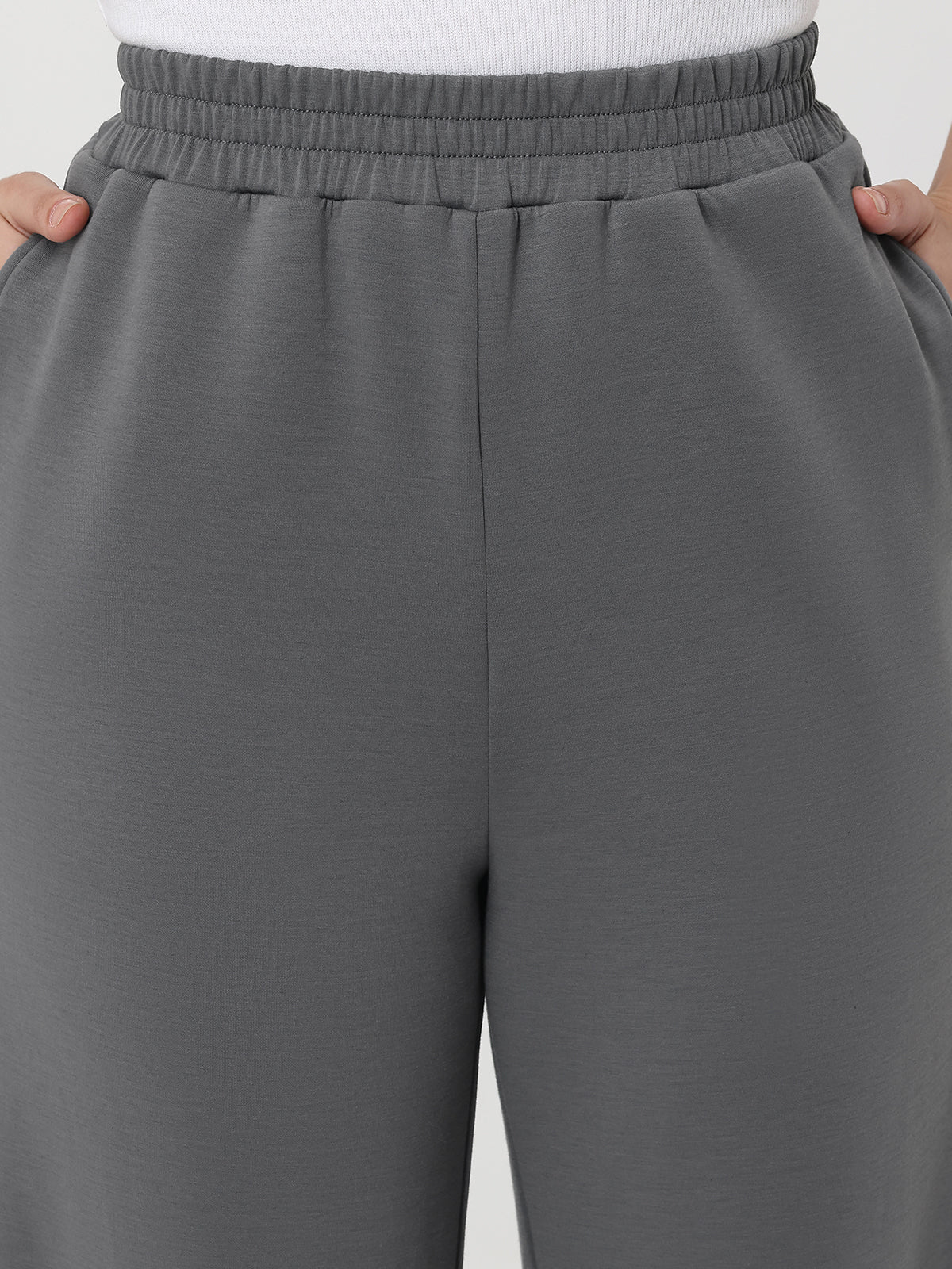 Gray pants with an elastic waistband on a plain background