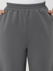 Gray pants with an elastic waistband on a plain background