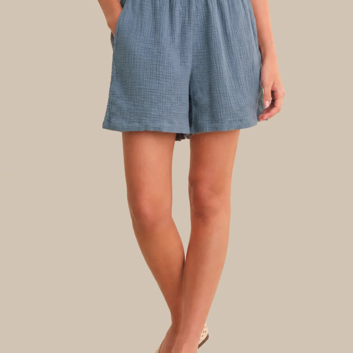 Person wearing a blue checkered skirt on a neutral background