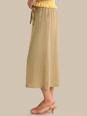 Beige skirt worn by a person on a plain background