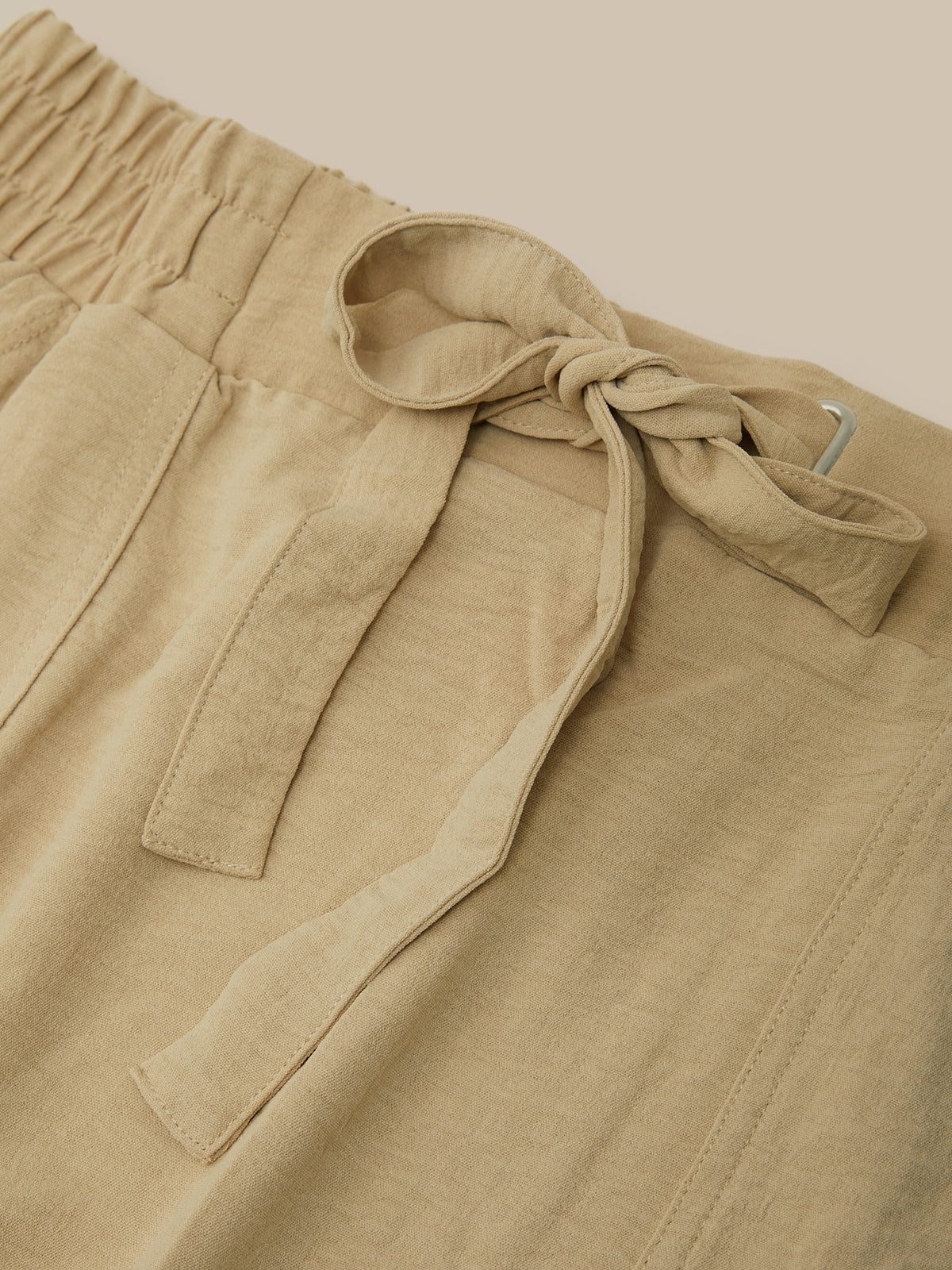 Beige pants with a tie detail on a beige background