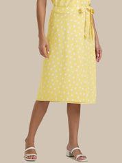 Person wearing a yellow polka dot dress on a beige background