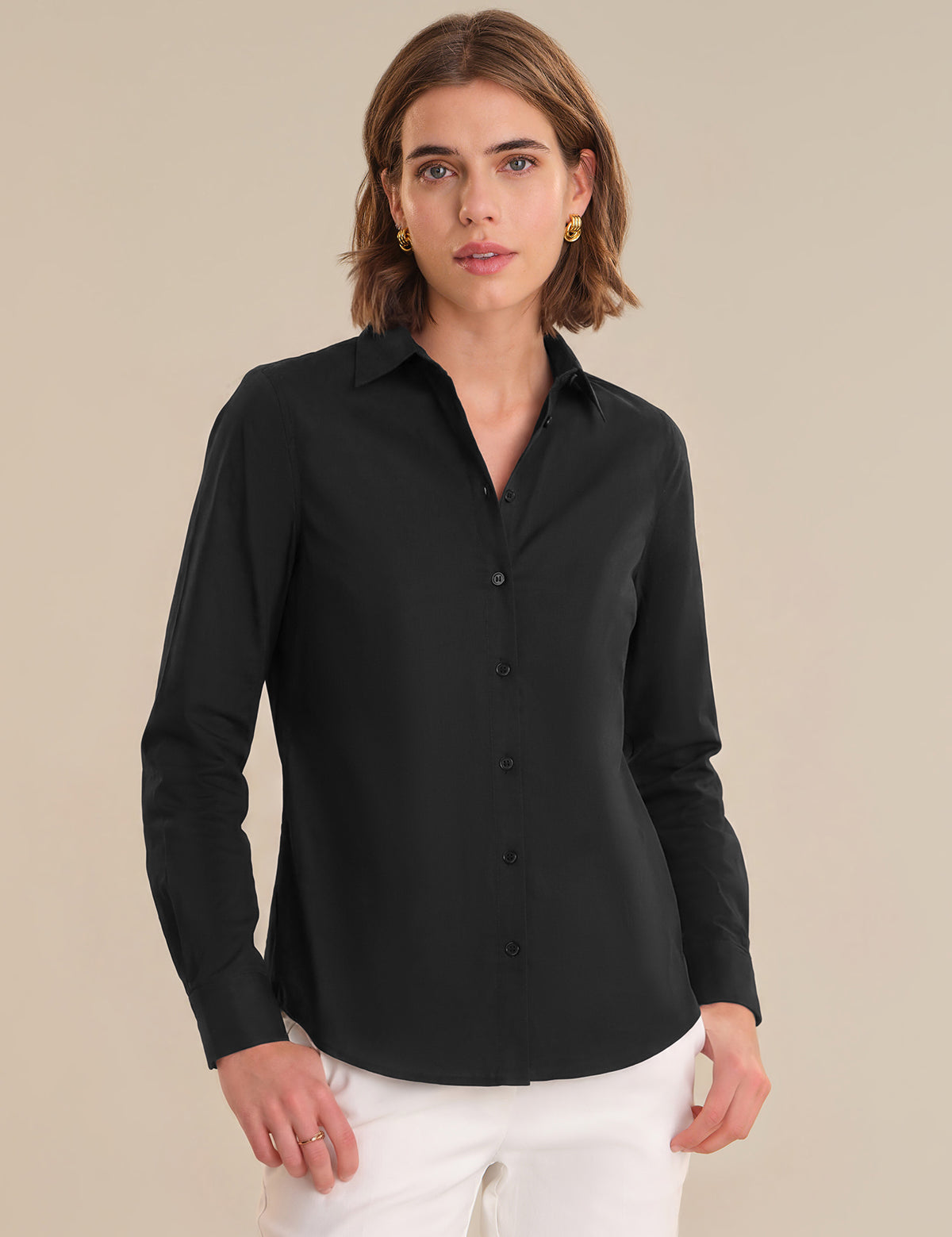 Woman wearing a black shirt against a beige background