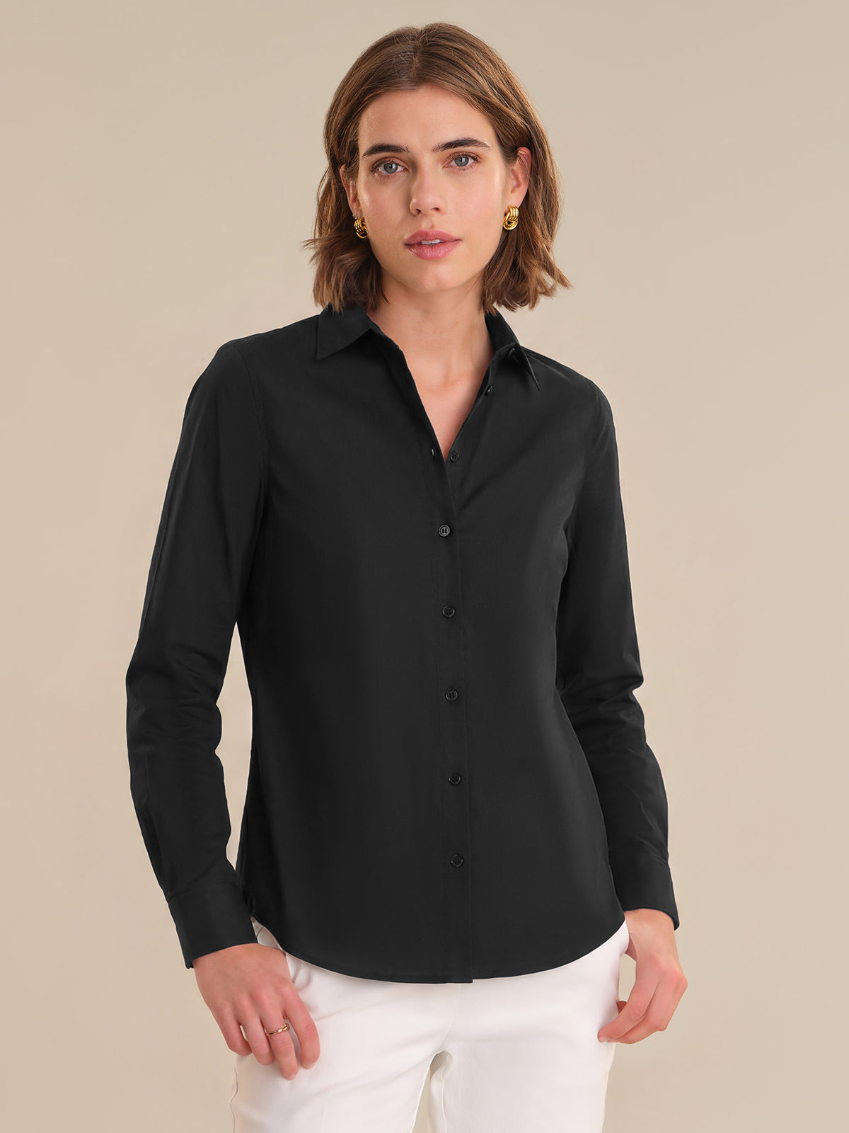 Woman wearing a black shirt against a beige background