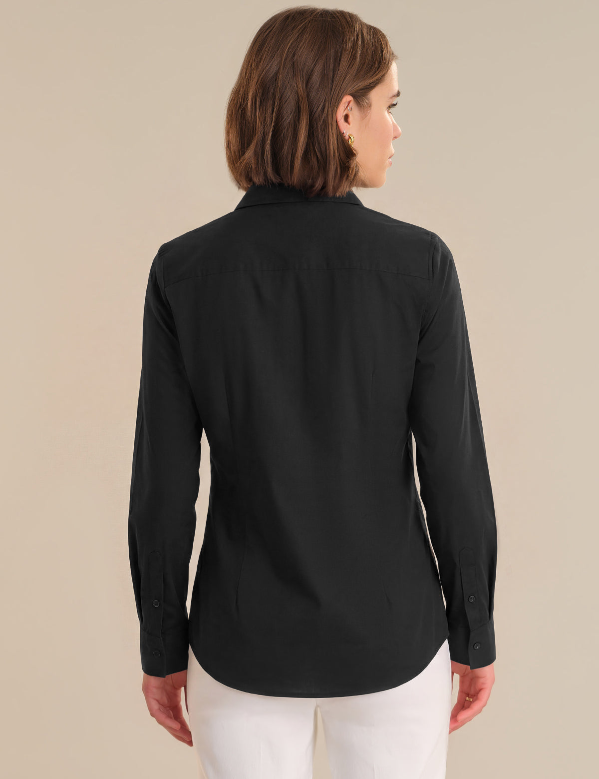 Woman wearing a black long-sleeve shirt against a beige background