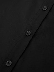 Close-up of a black shirt with buttons on a dark background