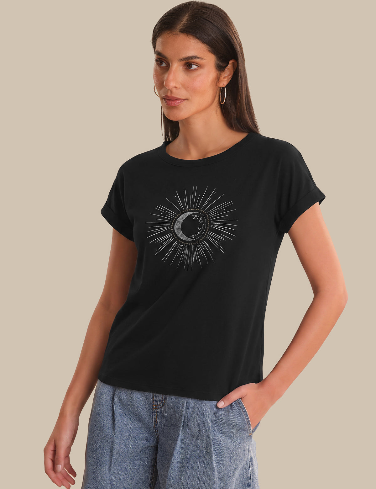 Woman wearing a black t-shirt with a sun and moon design on a beige background