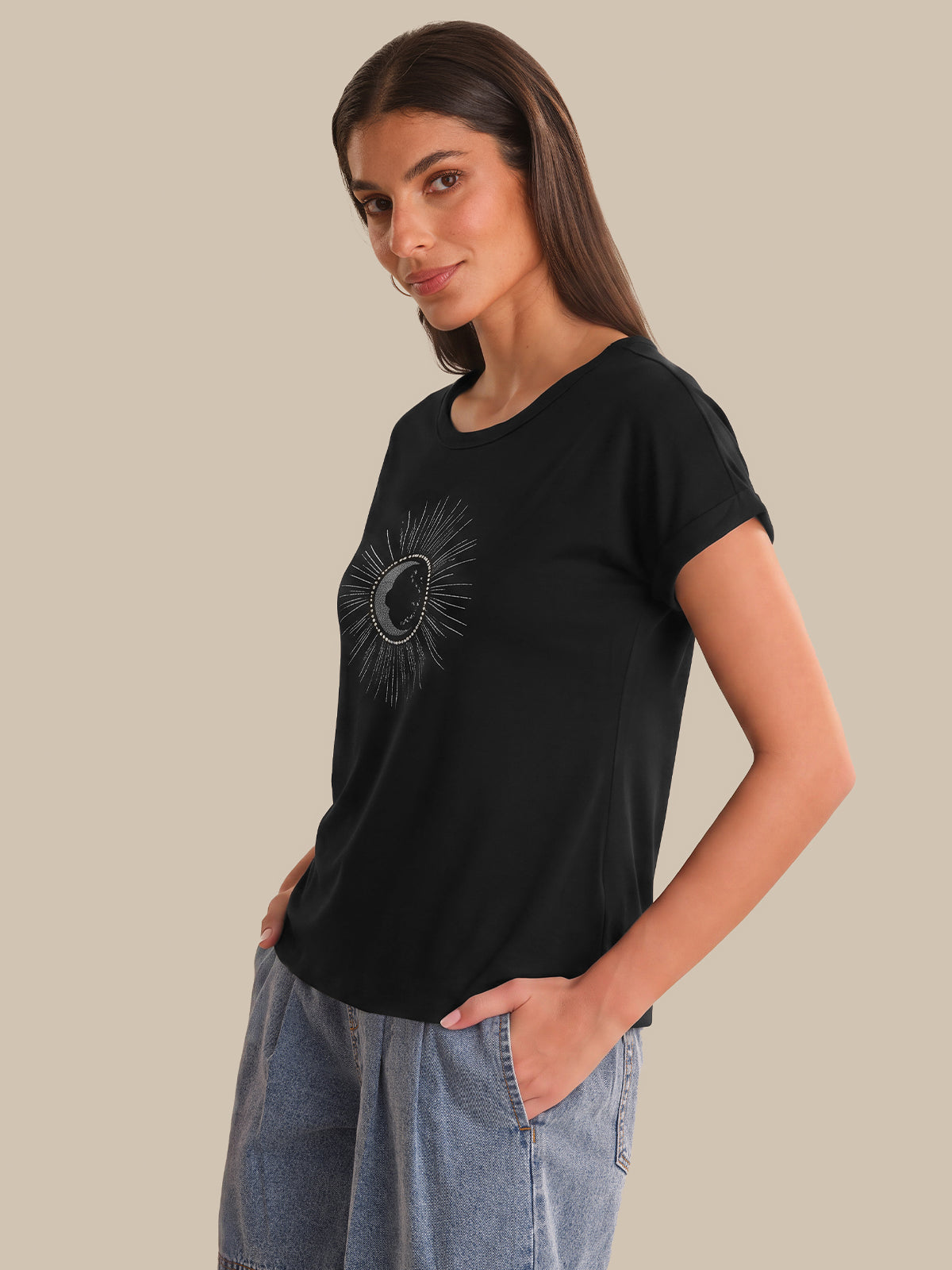Woman wearing a black t-shirt with a graphic design on a beige background