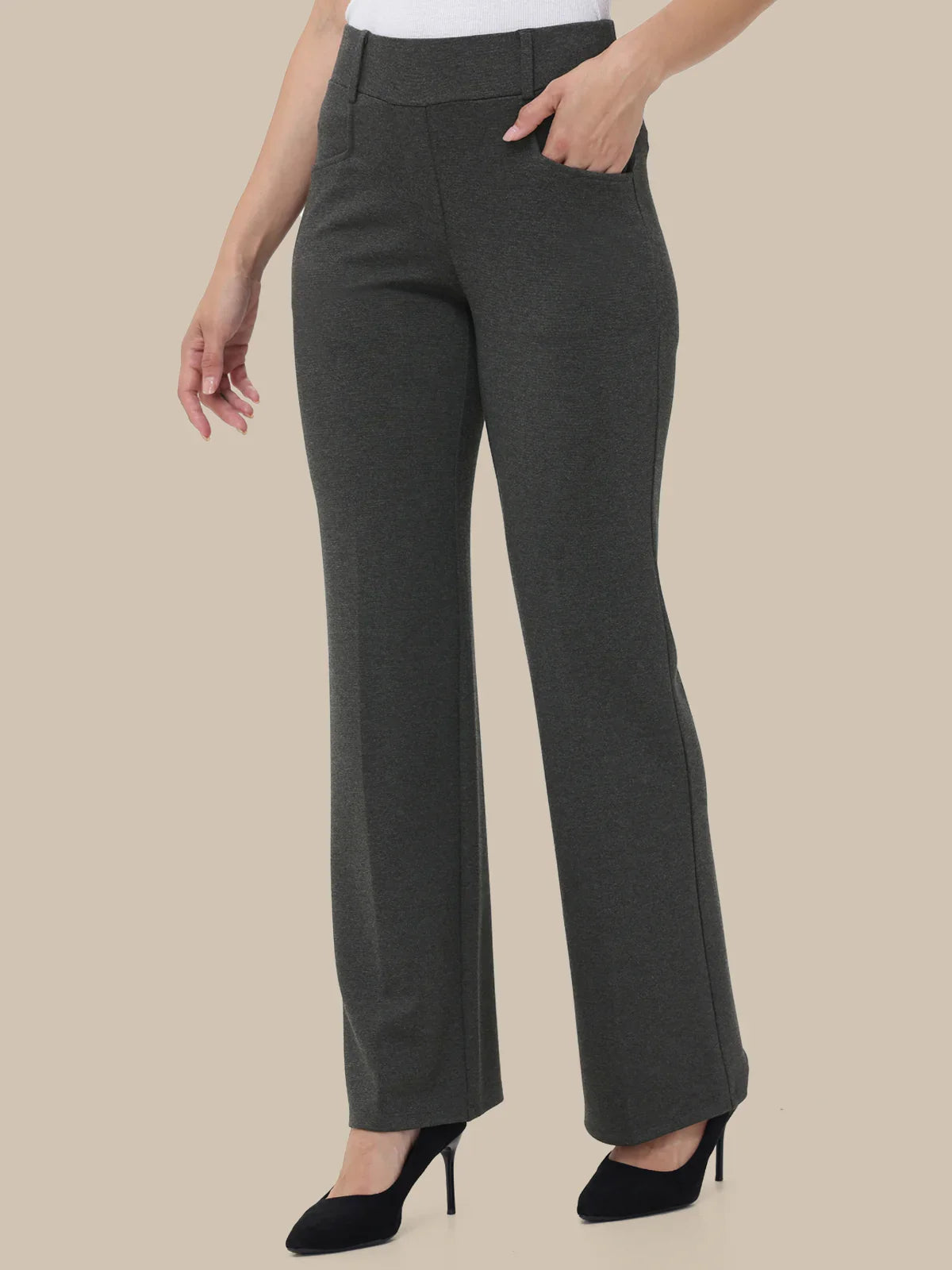 Dark gray pants worn by a person on a beige background