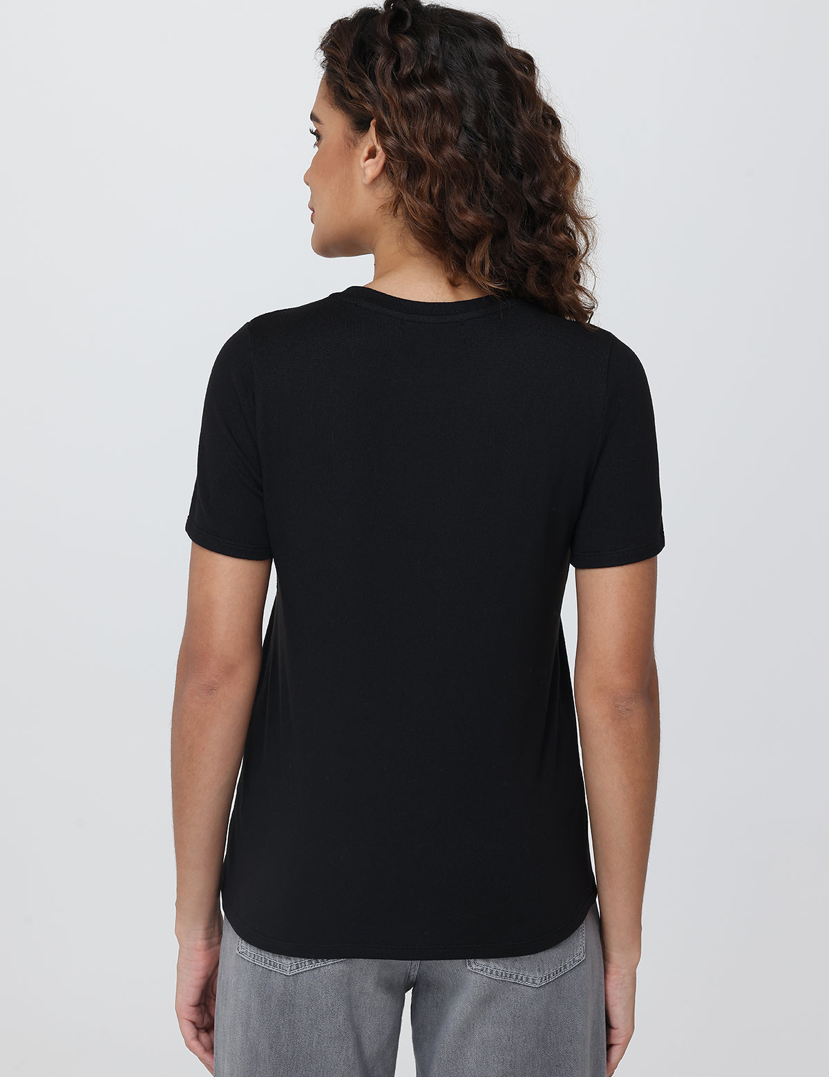 Person wearing a black t-shirt on a plain background