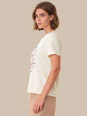Woman wearing a white t-shirt with a red graphic on a beige background