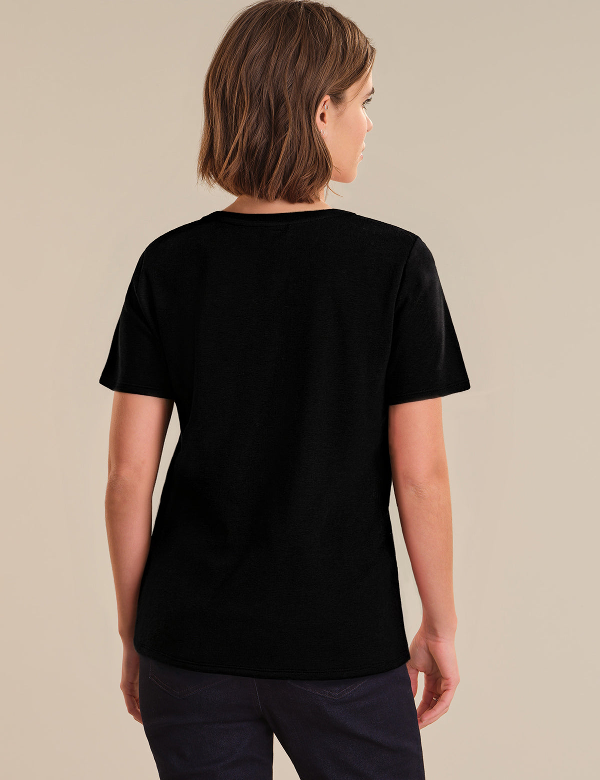 Person wearing a black t-shirt on a beige background
