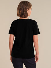 Person wearing a black t-shirt on a beige background