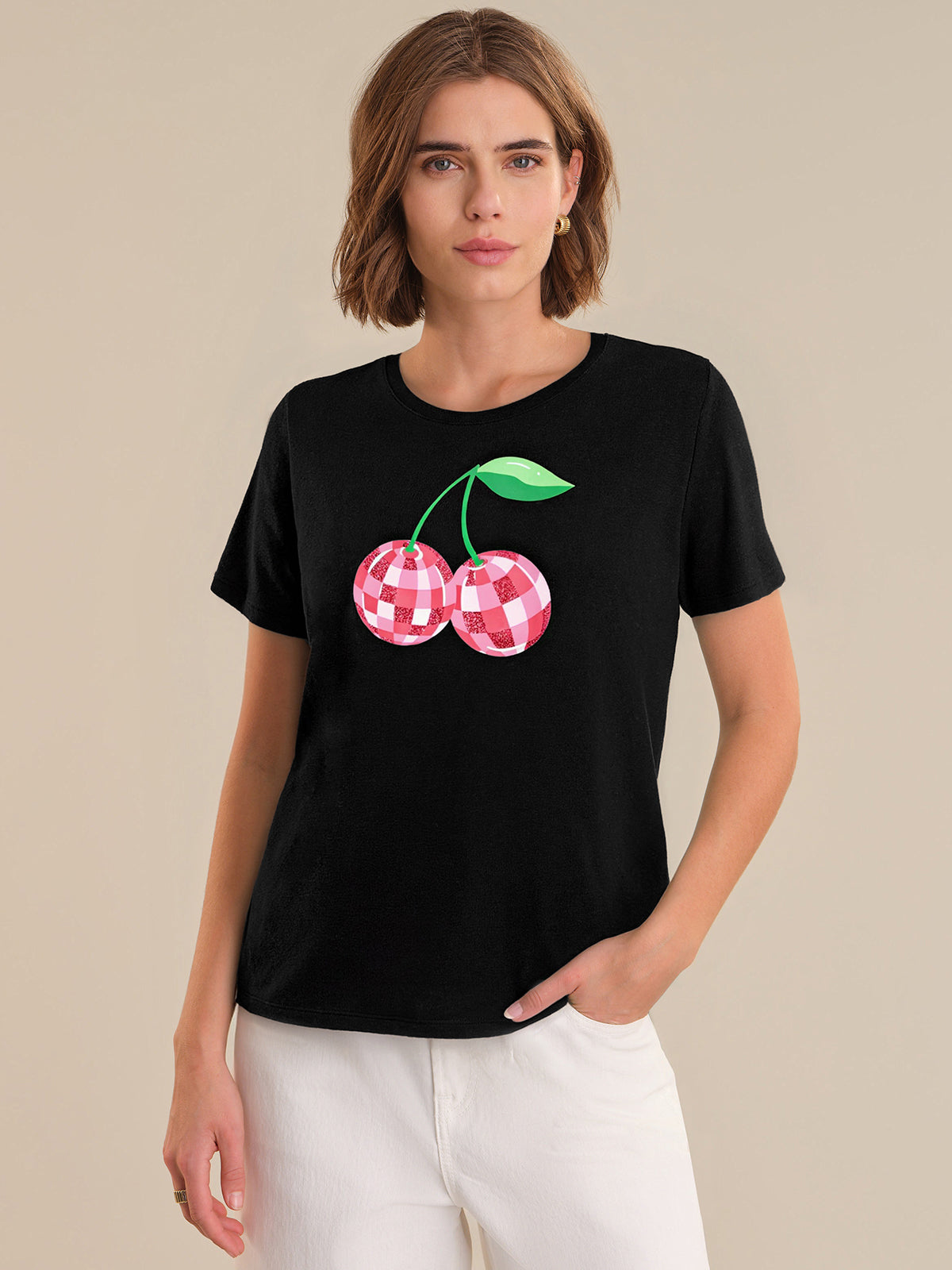Woman wearing a black t-shirt with a cherry design on a beige background
