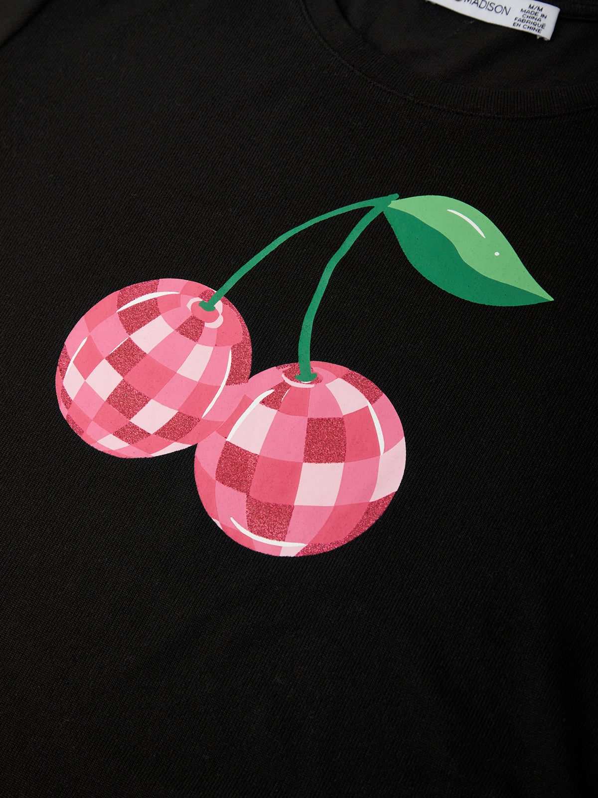 Black t-shirt with pink checkered cherries design on a plain background