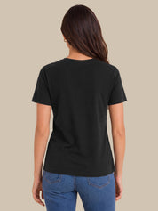 A woman viewed from the back wearing a plain black short-sleeve crewneck T-shirt and blue jeans, set against a solid beige background.