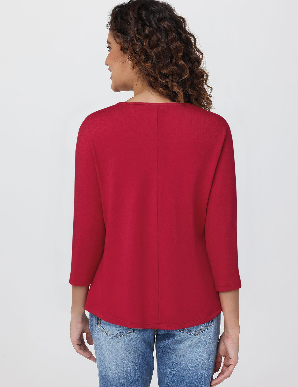 Woman wearing a red top and blue jeans on a white background