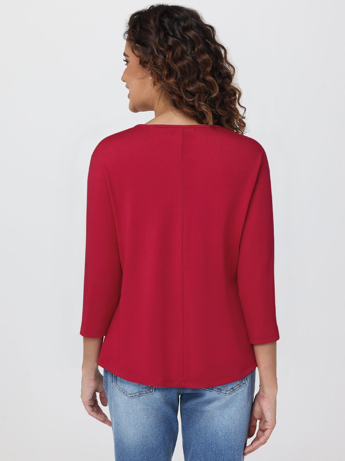 Woman wearing a red top and blue jeans on a white background