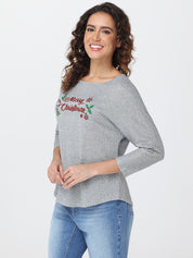Woman wearing a gray top with 'Merry Christmas' text on a white background