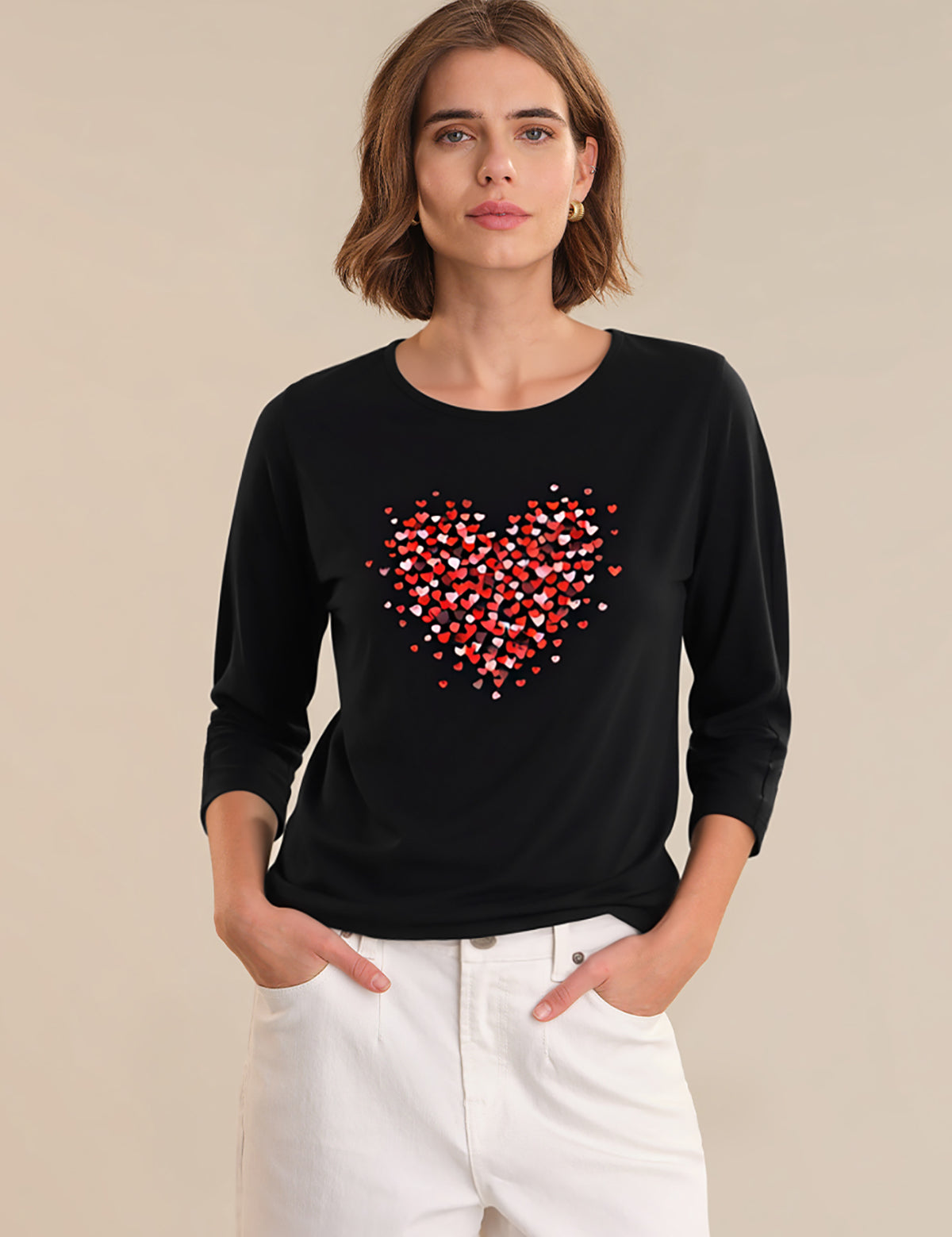 Woman wearing a black long-sleeve shirt with a red heart design on a beige background