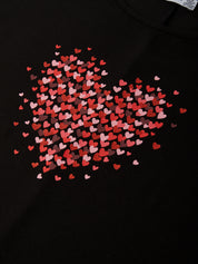 Black t-shirt with a design of red and pink hearts on a plain background