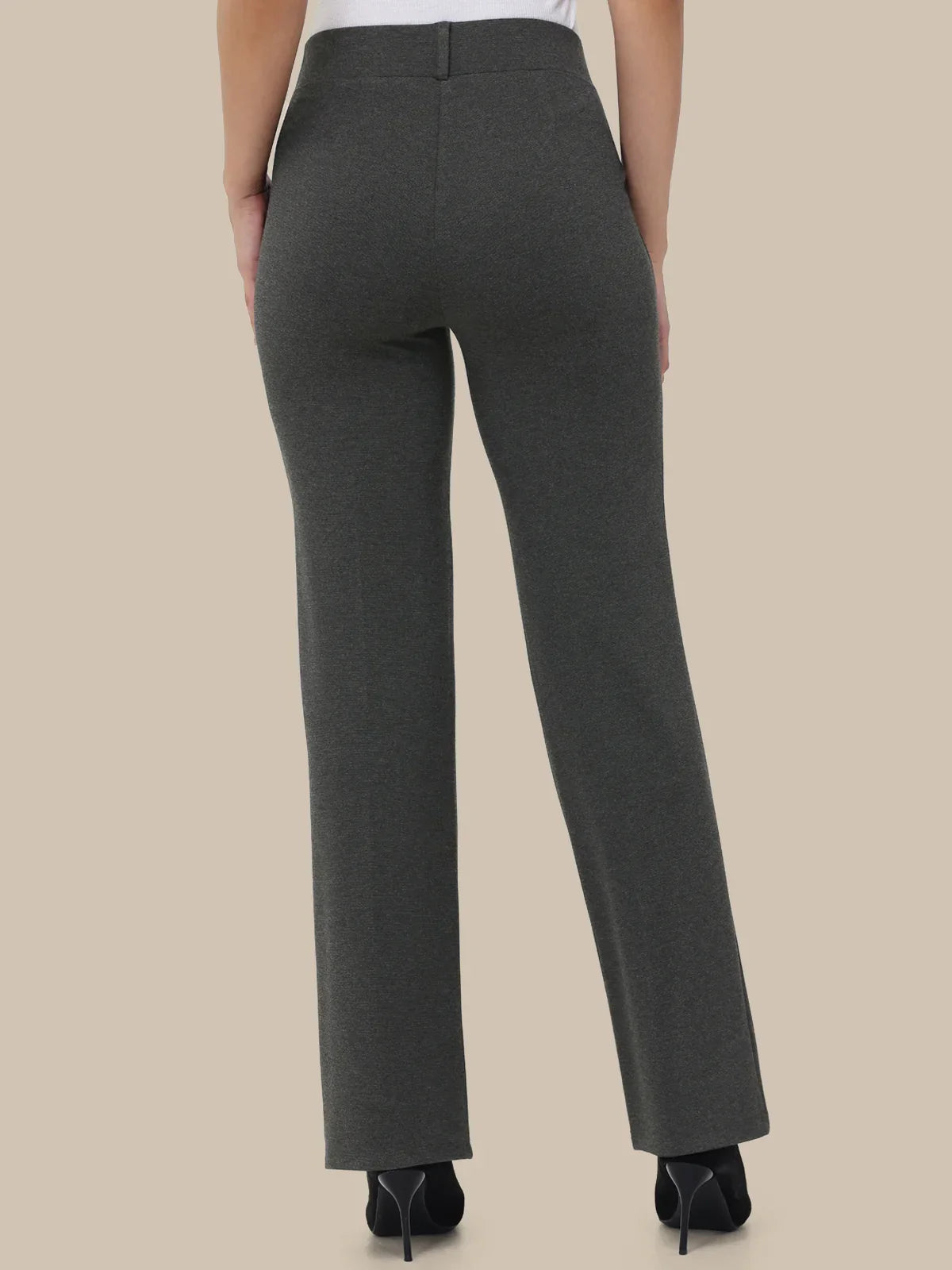 Dark gray pants worn by a person on a beige background