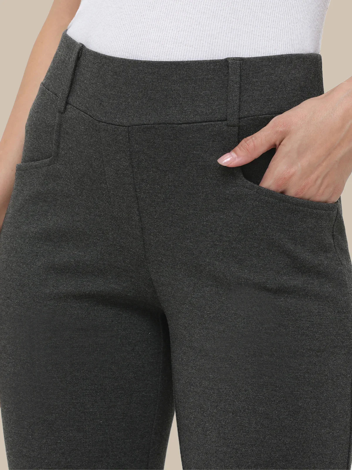 Dark gray pants with a white top on a neutral background