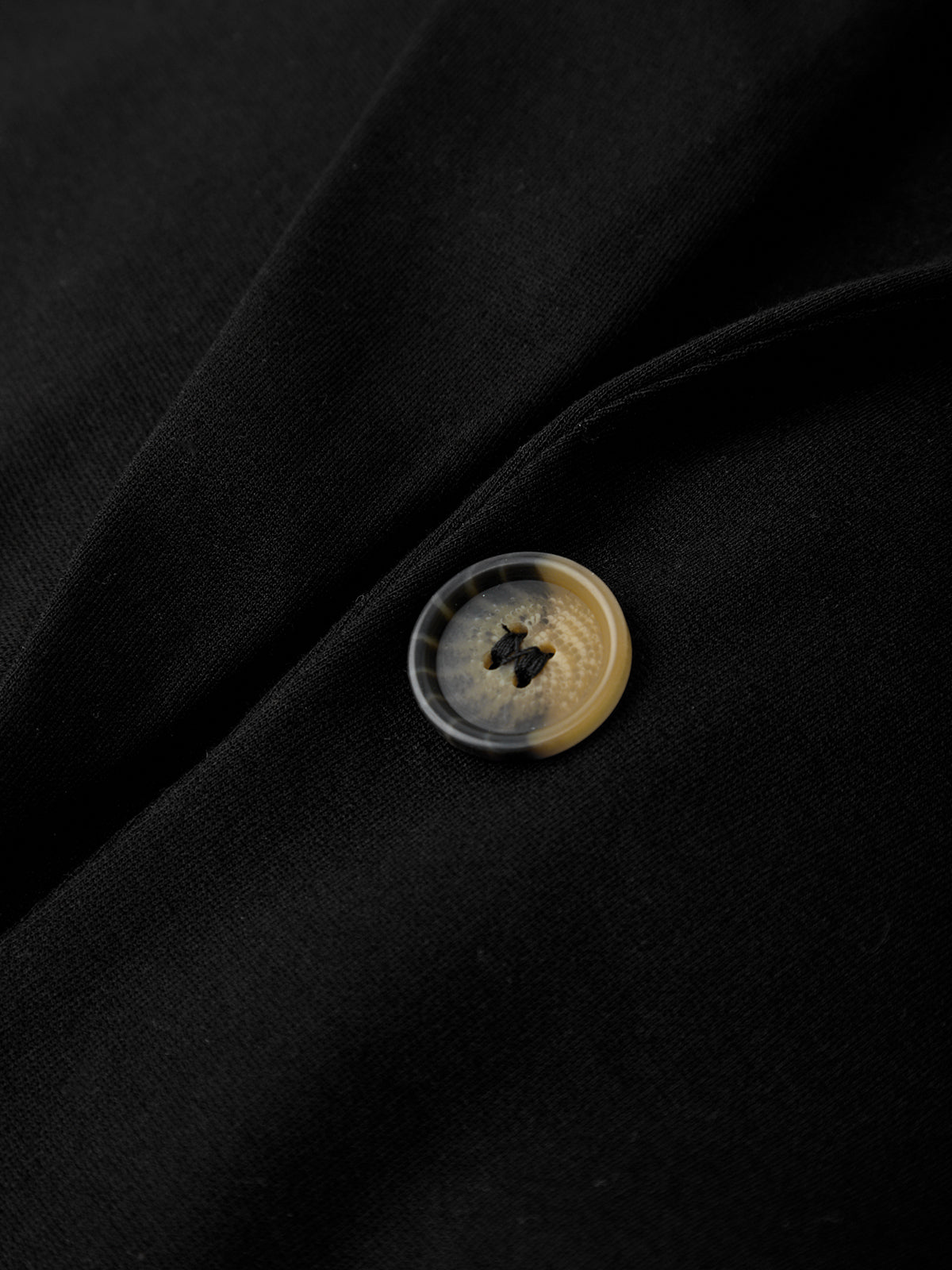 Close-up of a button on a black fabric background