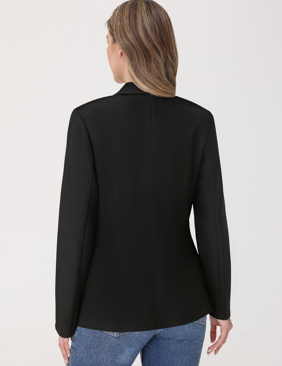 Person wearing a black blazer and blue jeans on a white background