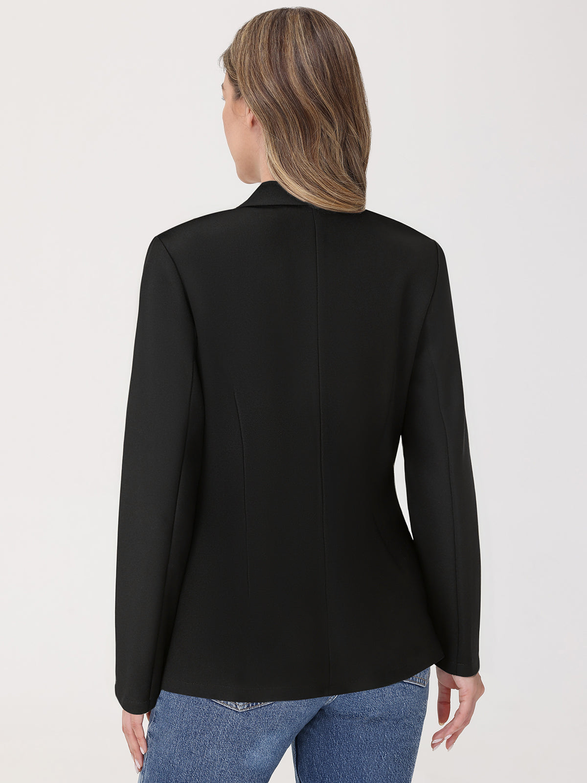 Person wearing a black blazer and blue jeans on a white background