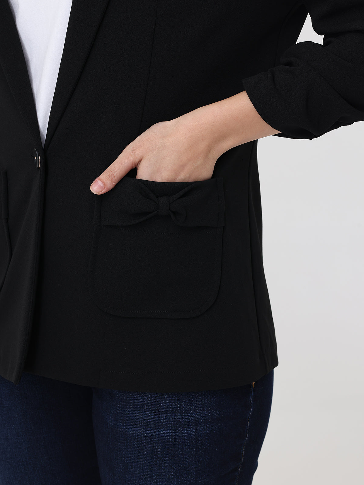 Person wearing a black blazer with a white background