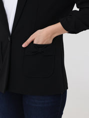 Person wearing a black blazer with a white background