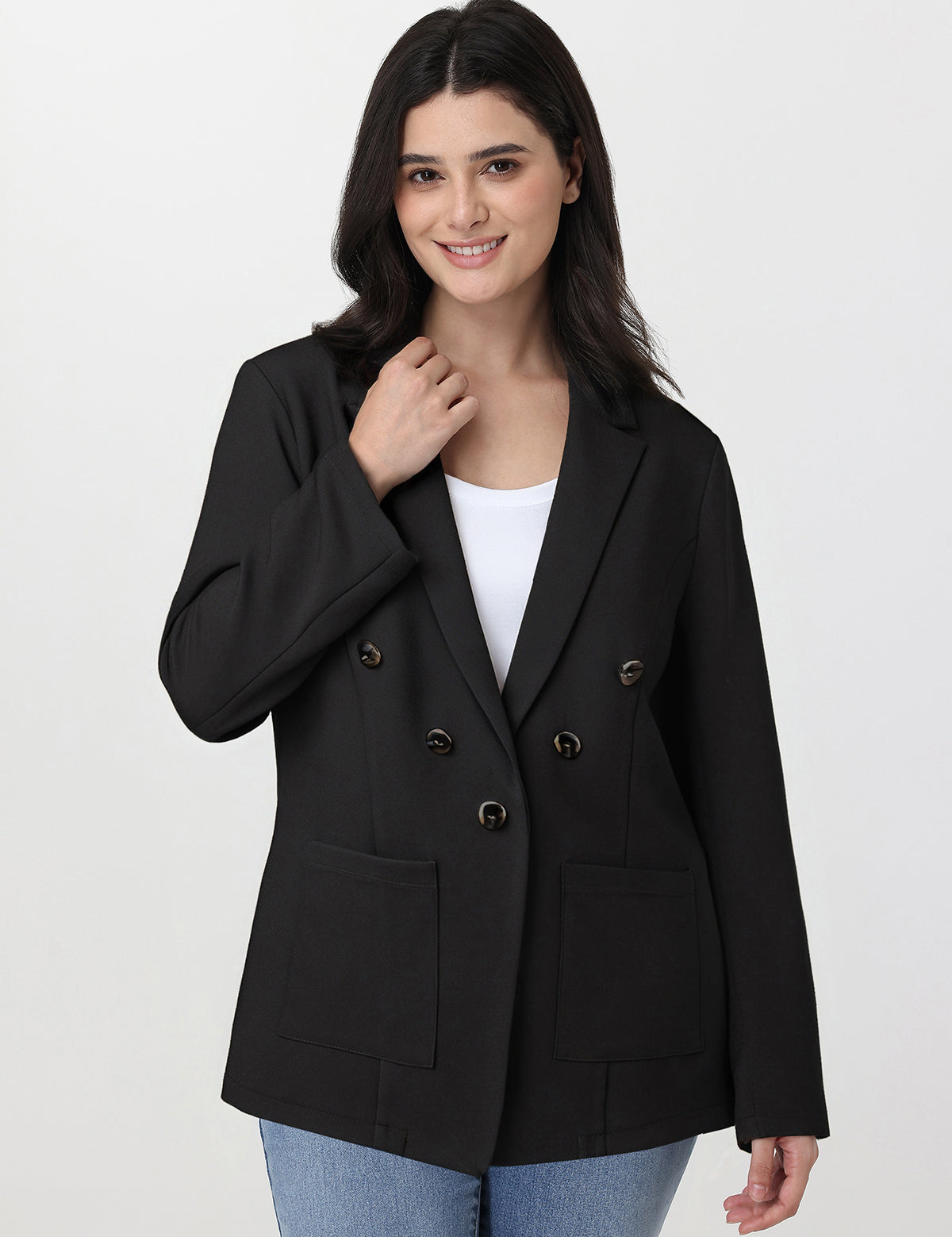 Woman wearing a black blazer over a white top on a light gray background