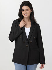 Woman wearing a black blazer over a white top on a light gray background