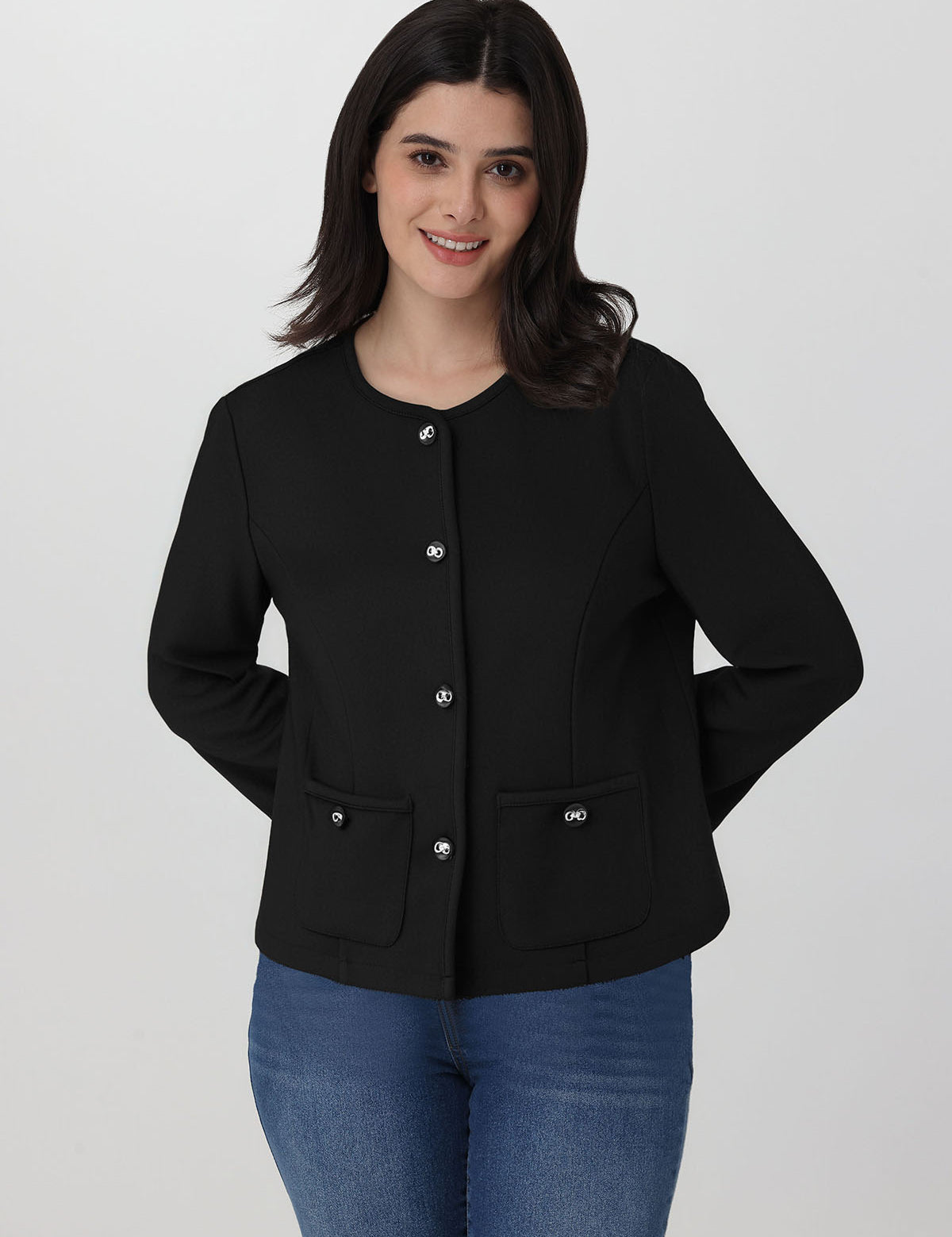 Woman wearing a black jacket with silver buttons on a white background