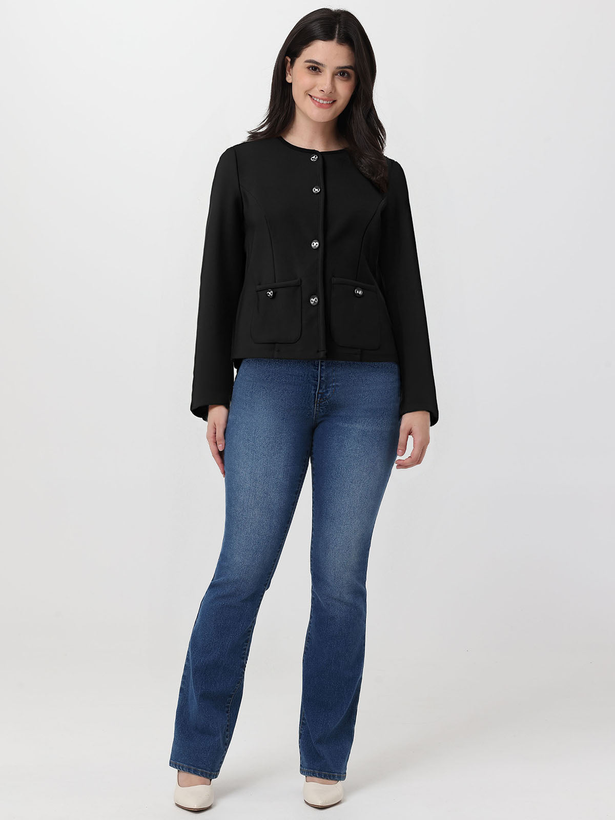 Woman wearing a black jacket and blue jeans on a white background
