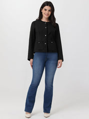 Woman wearing a black jacket and blue jeans on a white background