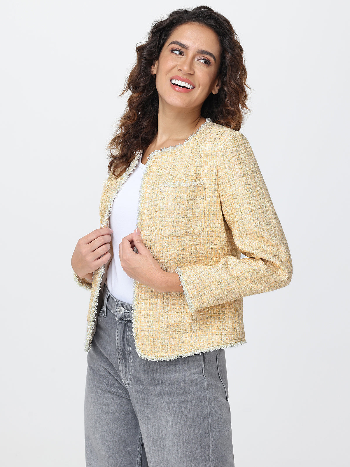 Woman wearing a yellow tweed jacket on a white background