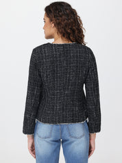 Person wearing a black checkered jacket and blue jeans on a light gray background