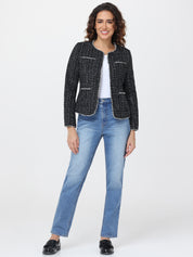 Woman wearing a black tweed jacket and blue jeans on a white background