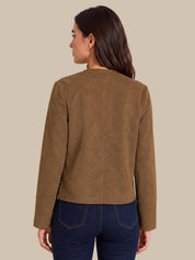 A woman shown from the back wearing a cropped, long-sleeve brown suede or faux-suede jacket and dark blue jeans, set against a solid beige background.