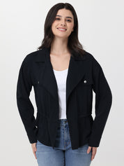 Woman wearing a black jacket over a white shirt and blue jeans on a white background