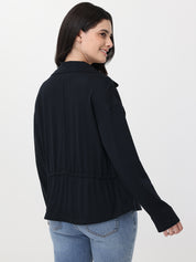 Woman wearing a black jacket and blue jeans on a white background