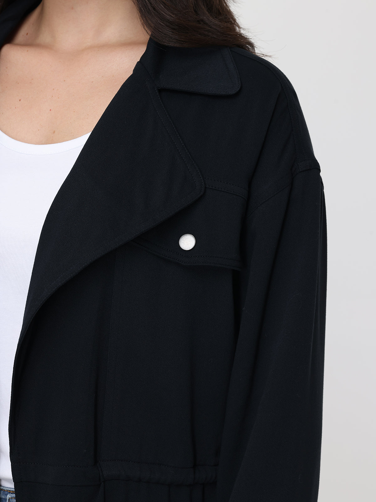 Black jacket worn by a person on a white background