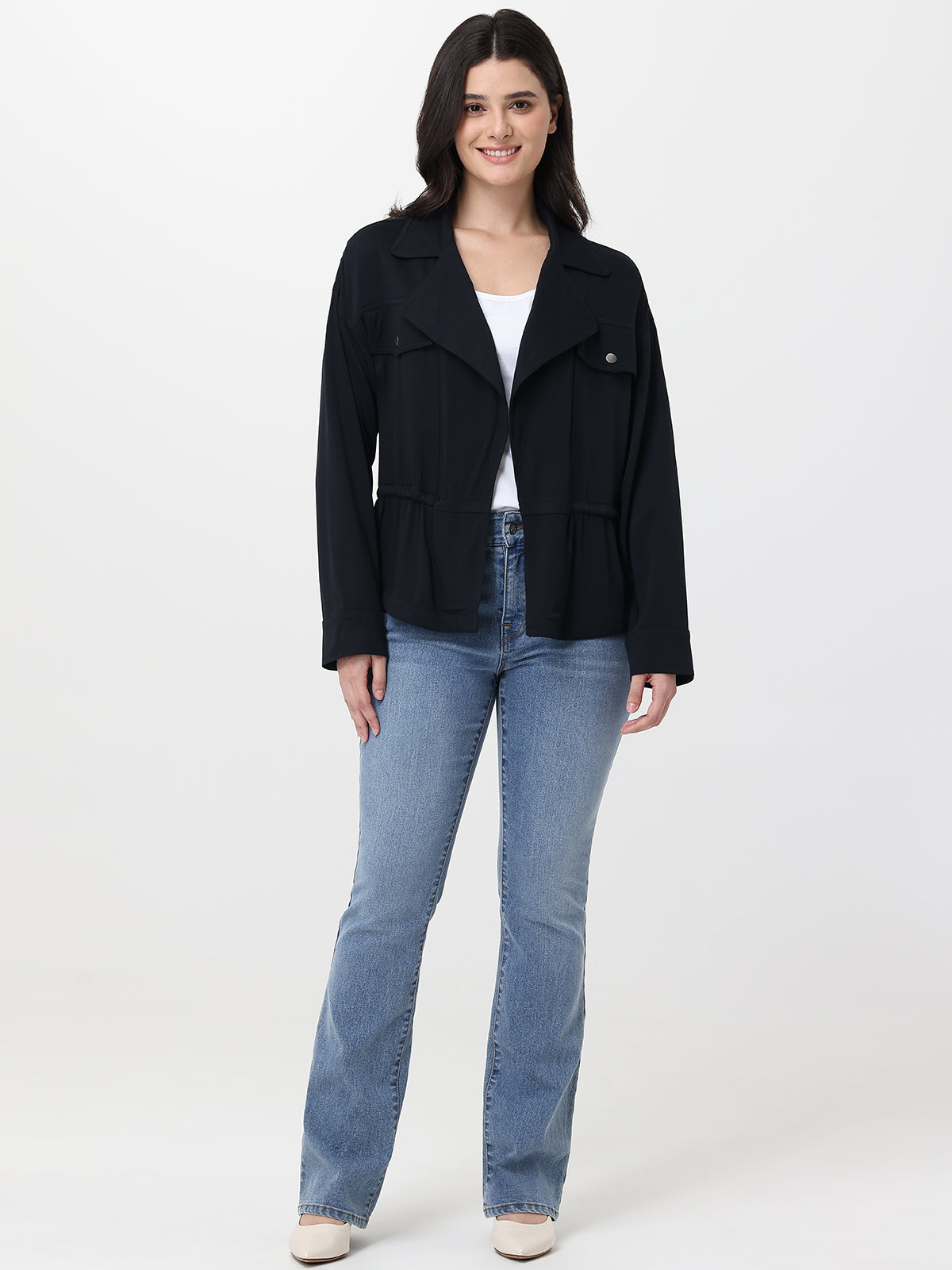 Woman wearing a black jacket and blue jeans on a white background
