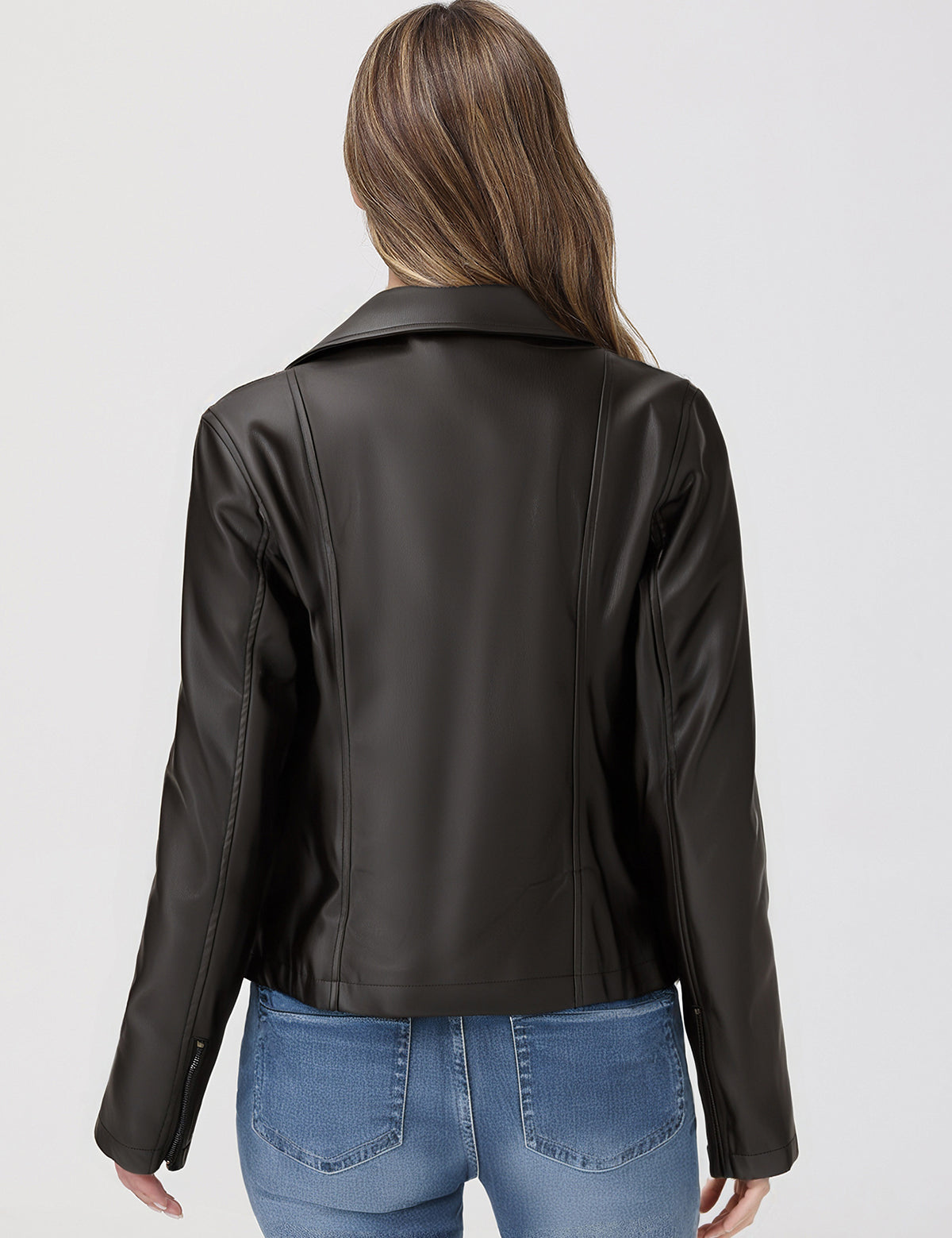 Person wearing a black leather jacket and blue jeans on a white background