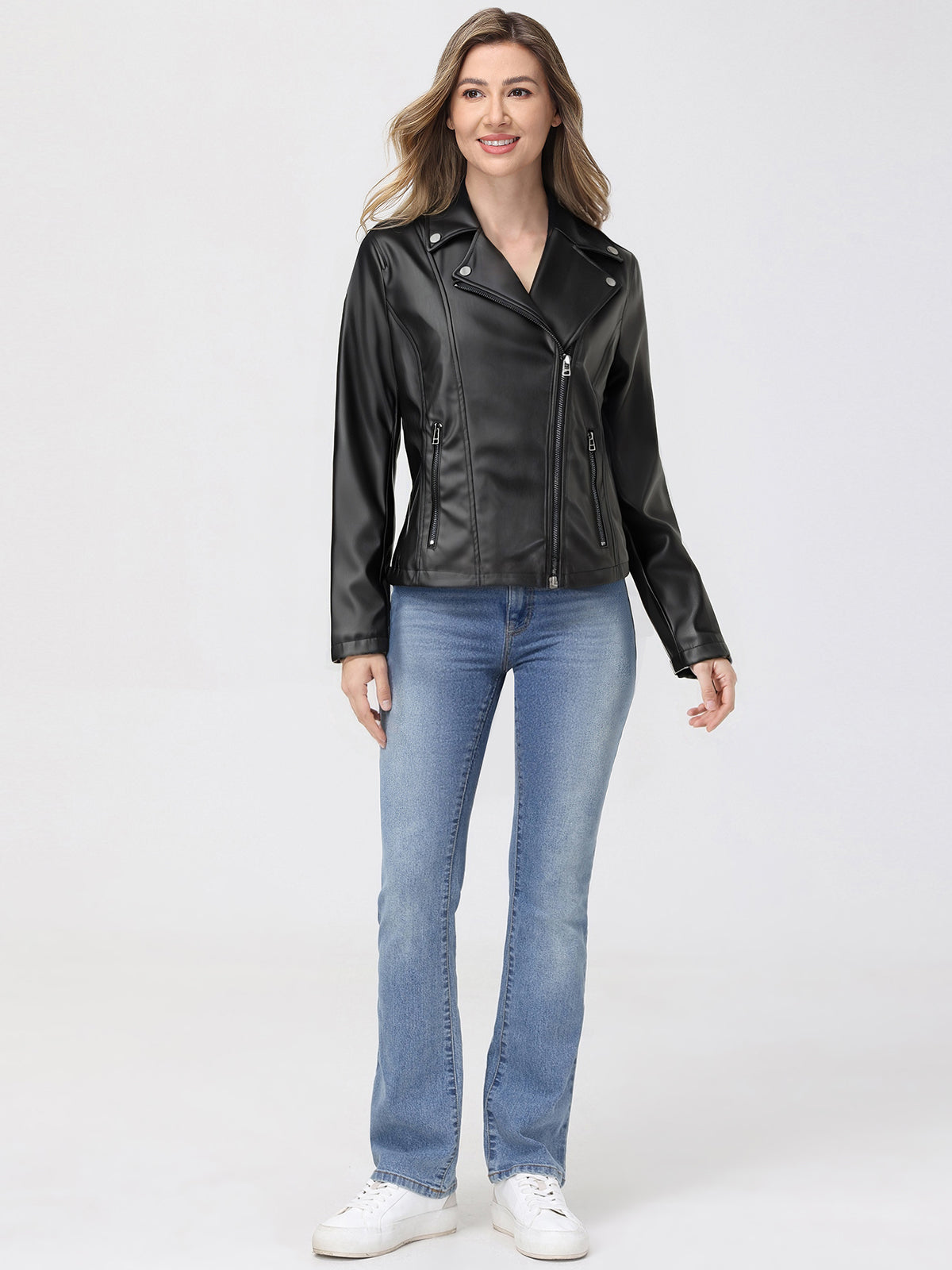 Woman wearing a black leather jacket and blue jeans on a white background