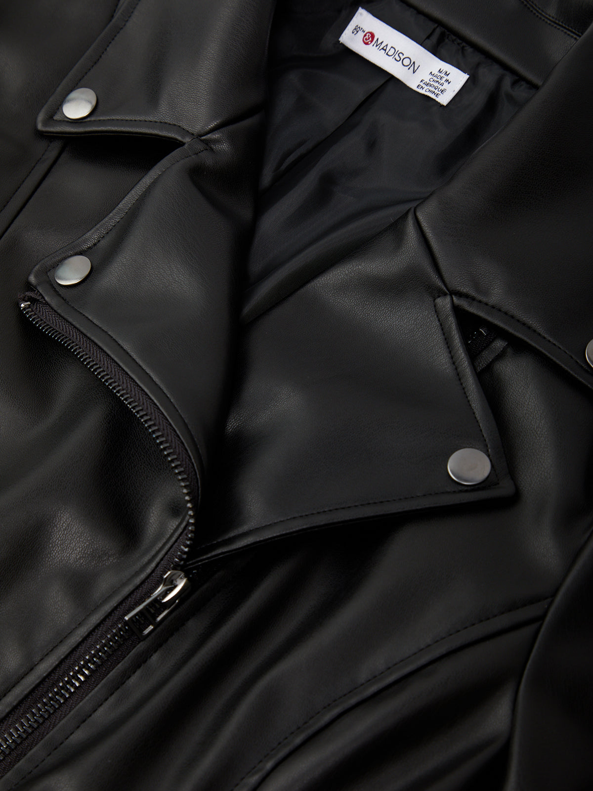 Close-up of a black leather jacket with a brand label visible.