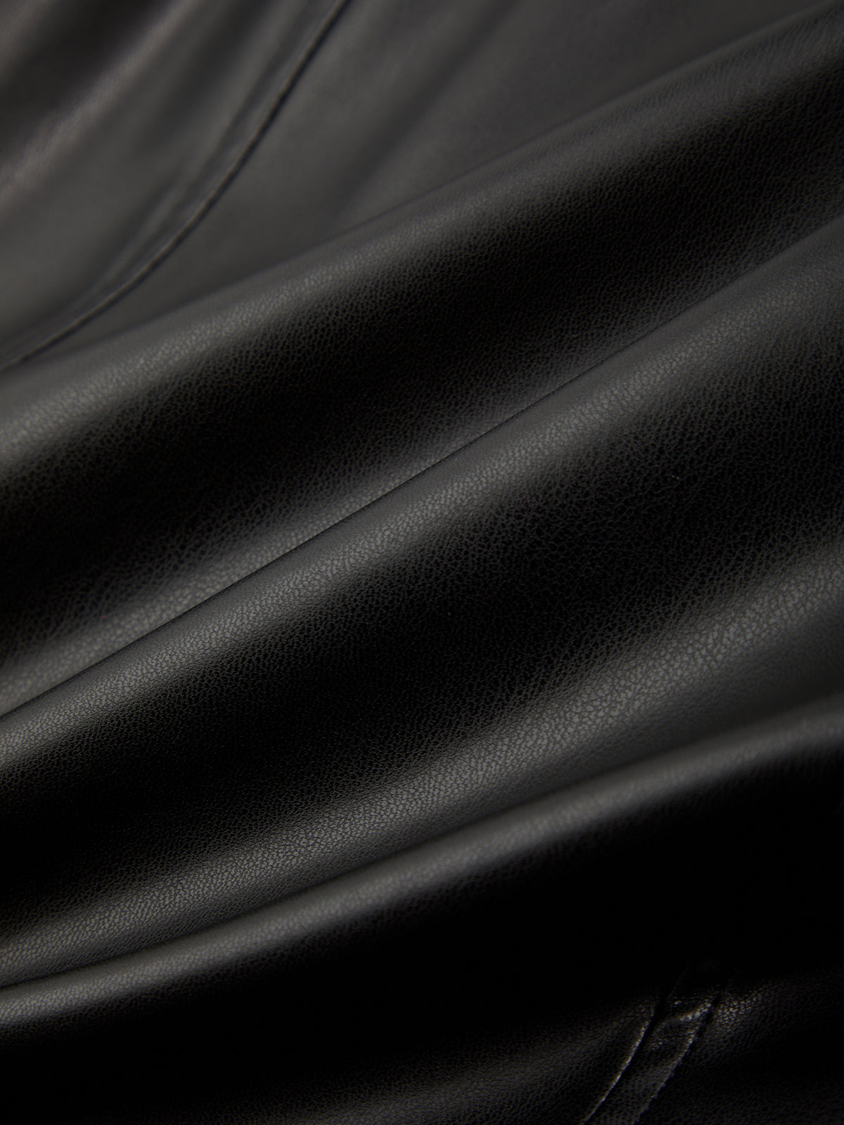 Close-up of black leather fabric with folds