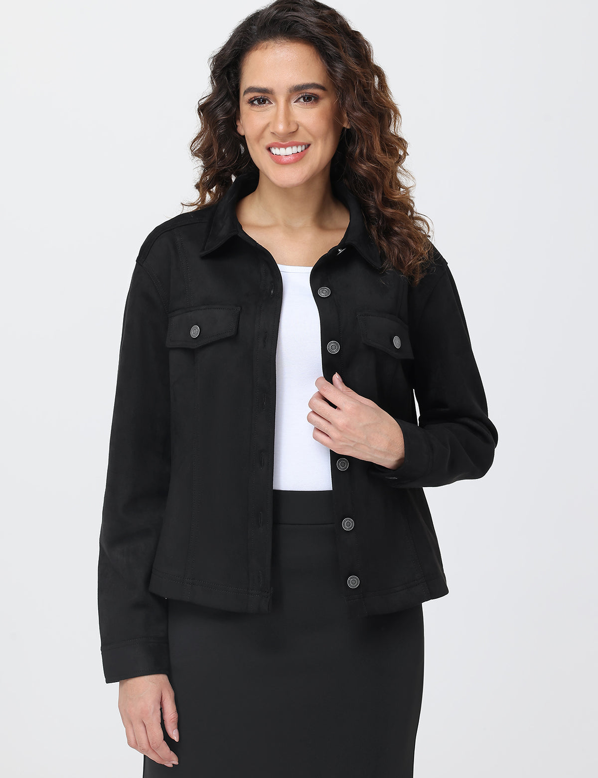 Woman wearing a black jacket over a white shirt on a plain background